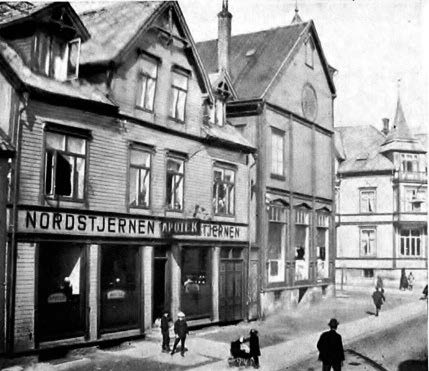 Apoteket Nordstjernen, Storgt 42 i Tromsø ca. 1920. Til høyre for apoteket er Baptistkirken og Grand Hotell i bakgrunnen. Ukjent fotograf.